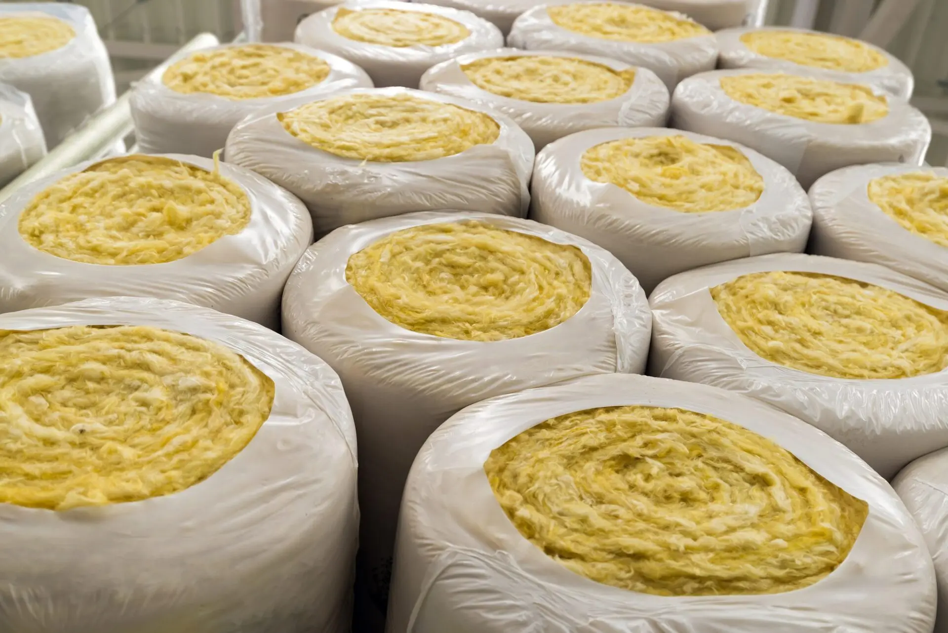 Bales of yellow insulation rolls wrapped in plastic