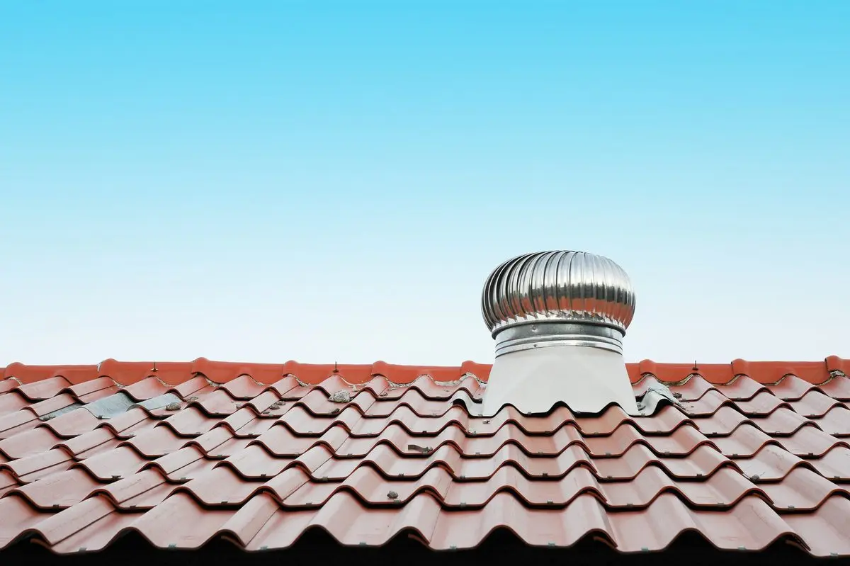 Metal ventilator on red tiled roof
