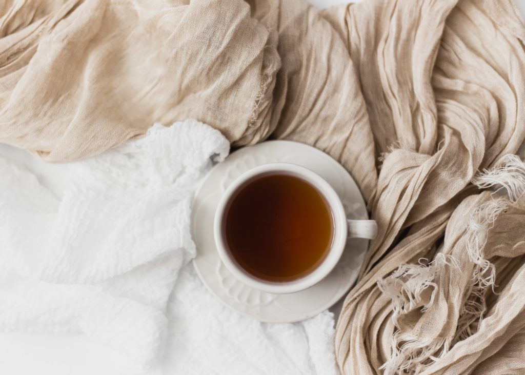 Cup of tea surrounded by blankets