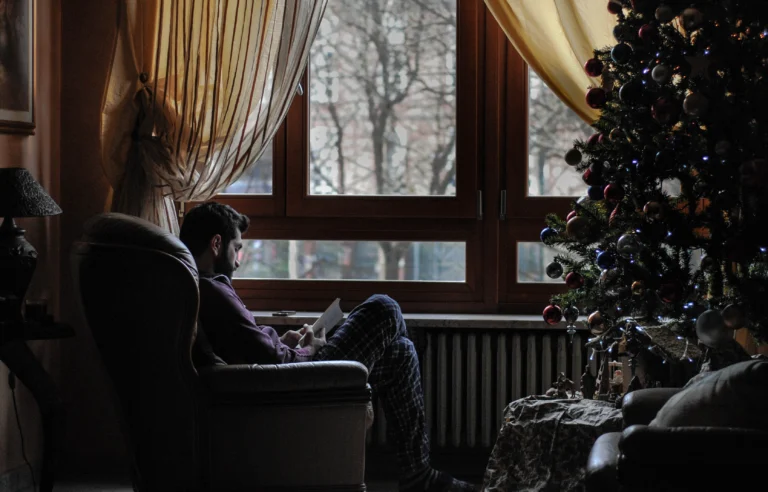 Man reading by Christmas tree