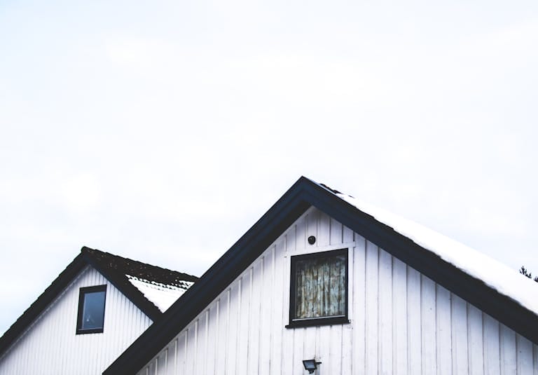 Snow-covered roof of a white house