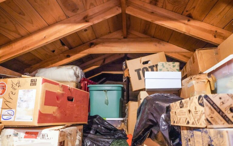 Cluttered attic with boxes and storage items.