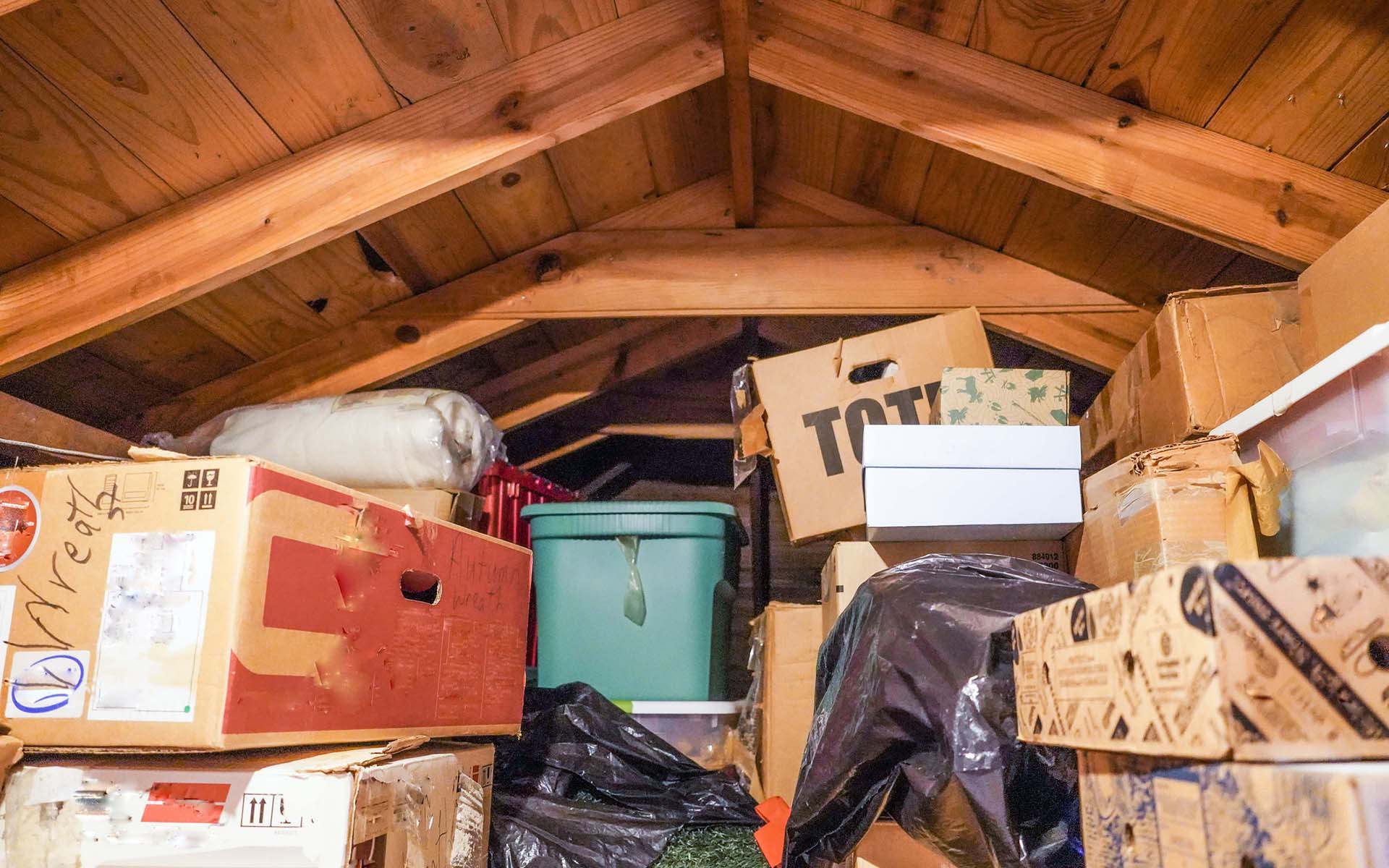 Cluttered attic with boxes and storage items.