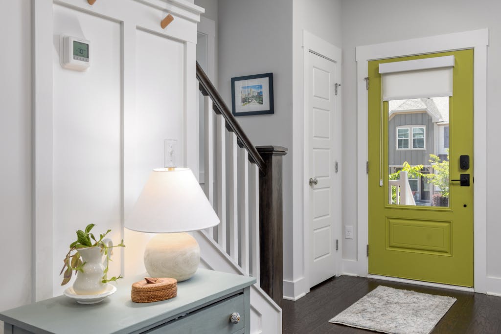 Bright entryway with green door and staircase
