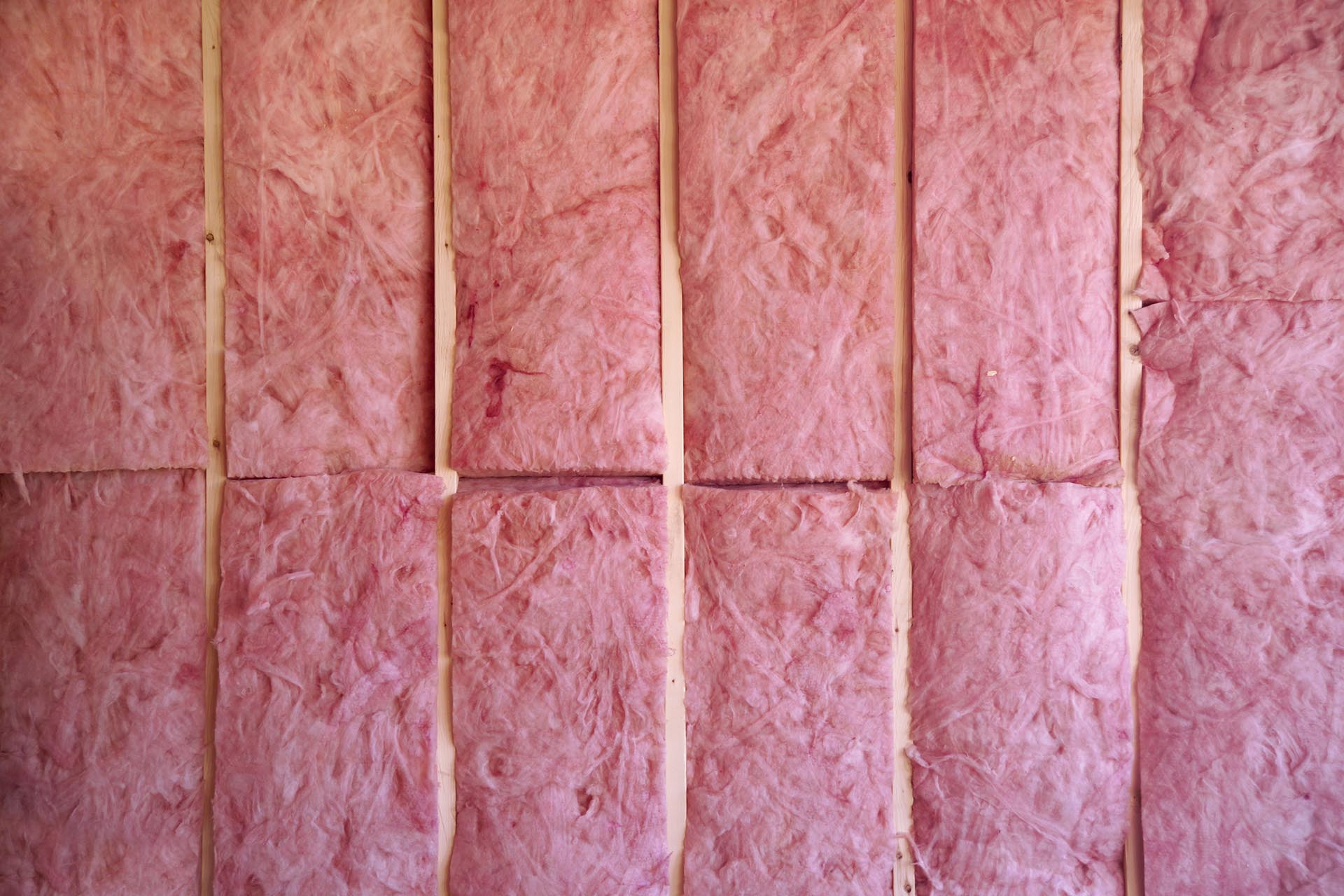 Pink fiberglass insulation installed in wall frame
