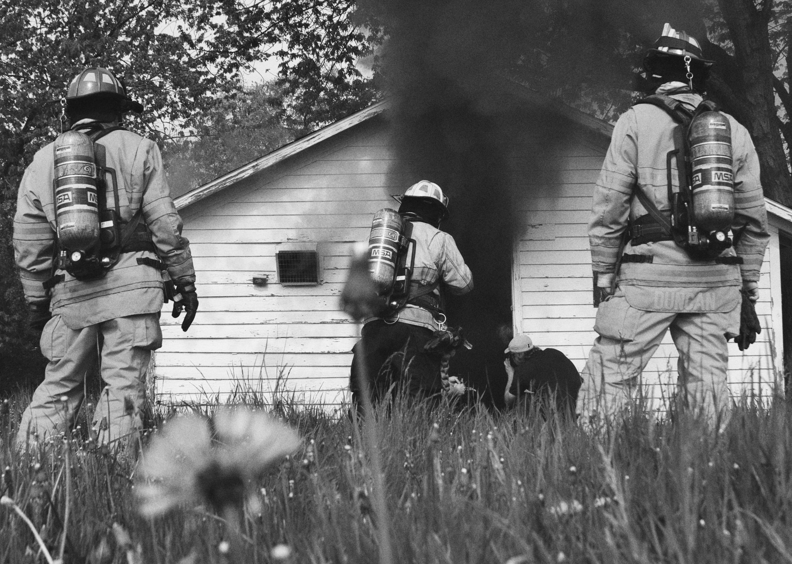 Firefighters enter smoky building for rescue mission.