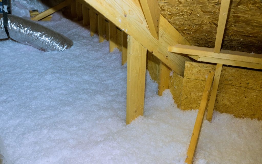 blown in insulation coating an attic floor. blown-in insulation costs