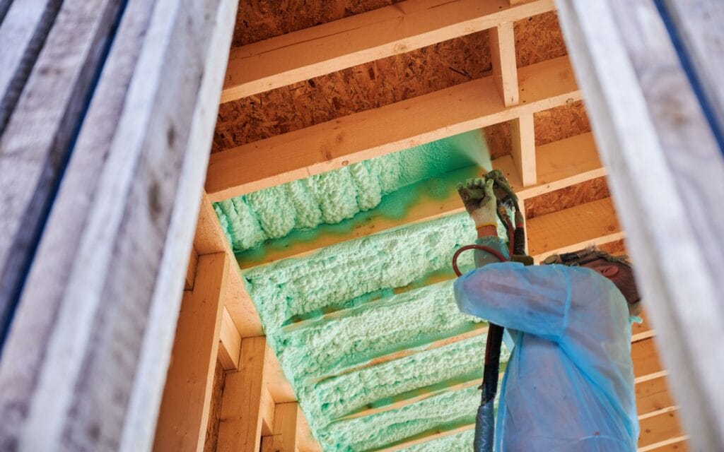 spray foam cost in san antonio. Worker applying green spray foam insulation